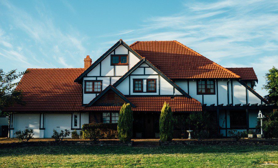 A large countryside house with white walls, wood beans and a red tiled roof