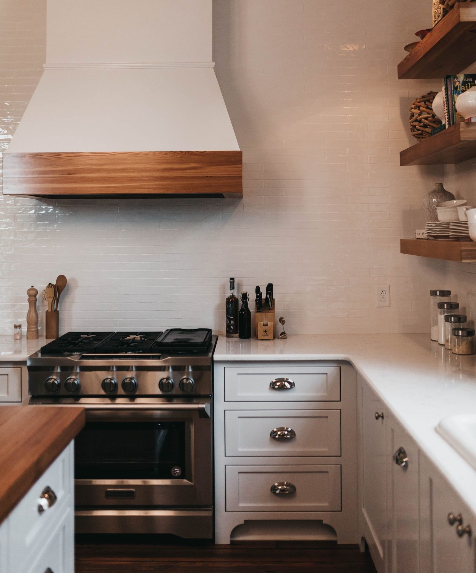 Buy-to-Let mortgages | A white kitchen with a large extractor fan over an oven and wooden tops