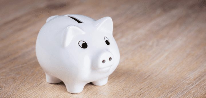 A white piggy bank on a wooden surface