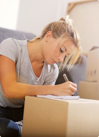 Mortgages for first-time buyers | Woman making notes on a notepad on top of a box