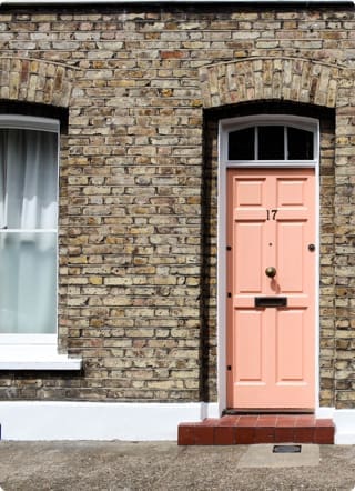 Right to Buy mortgages | A brick terrace house with a light pink coloured front door