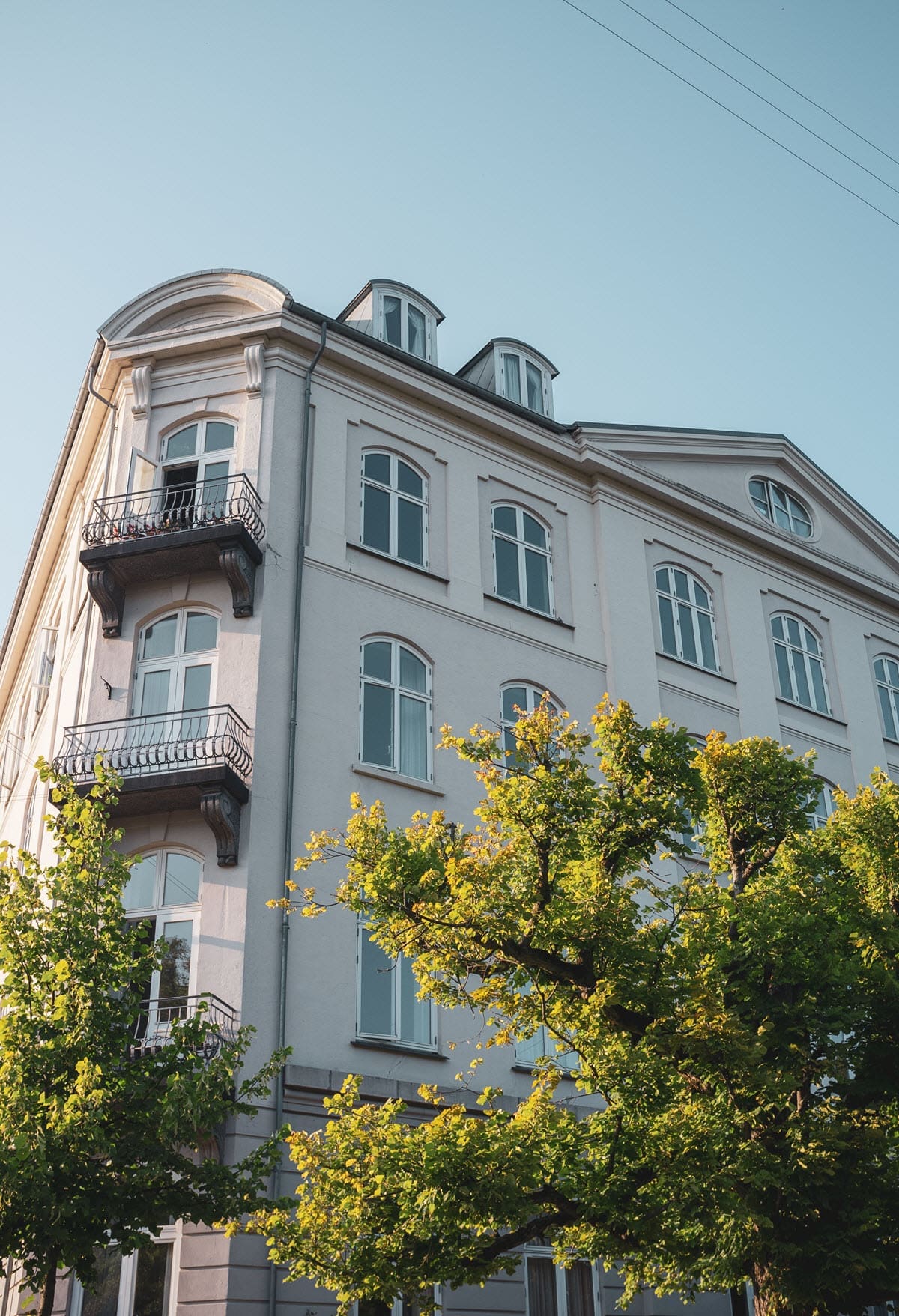 A block of flats with terraces with a clear blue sky in the background