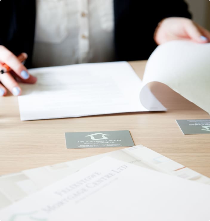 The Mortgage Centre business cards placed on a table with paperwork